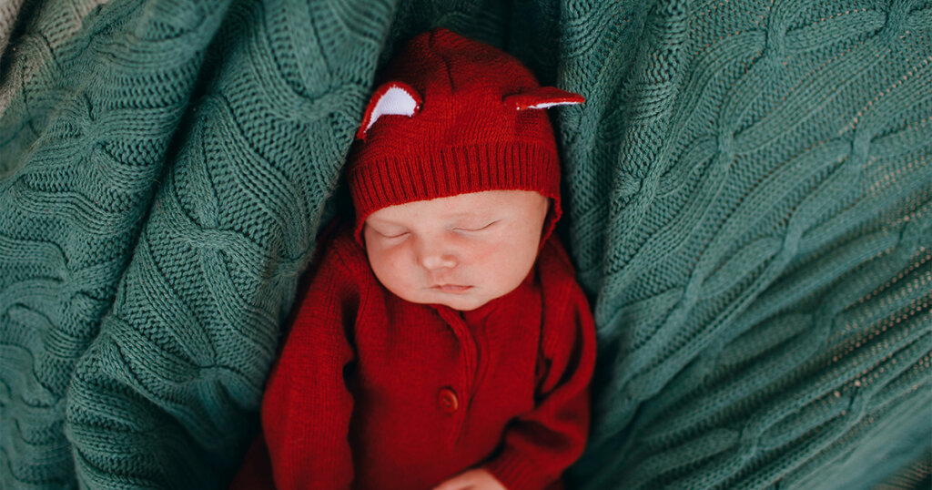 baby sleeping in red dress