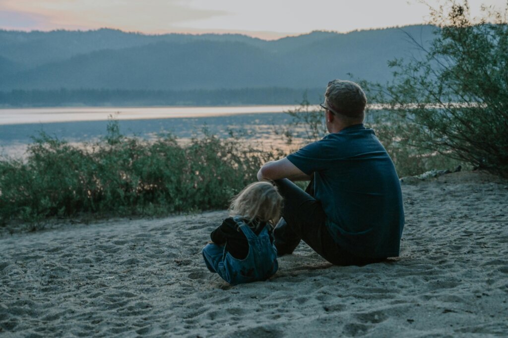 Father Sitting on Sand with a Child