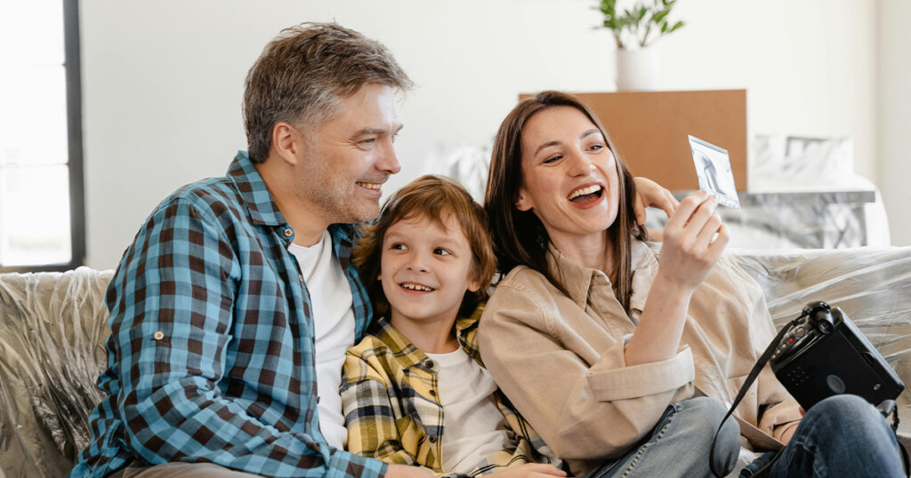 Man and Woman Smiling While Holding White Smartphone