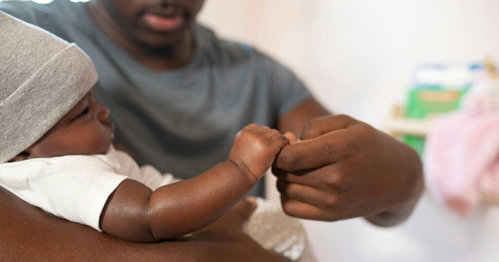 Shallow Focus Photo of Man Carrying His Baby
