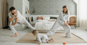Mom and dad doing yoga while baby playing