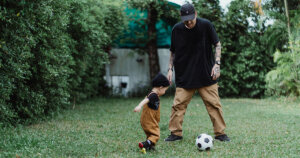 Father and baby playing football