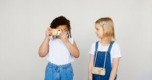 black girl using camera while white girl is watching her