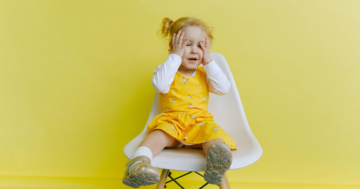 Girl In Yellow Dress Covering Her Face With Her Hands