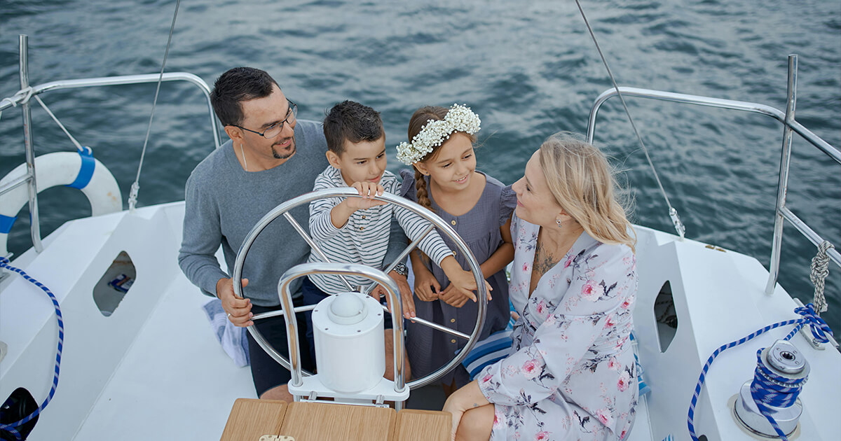 Happy family on yacht sailing on sea during trip