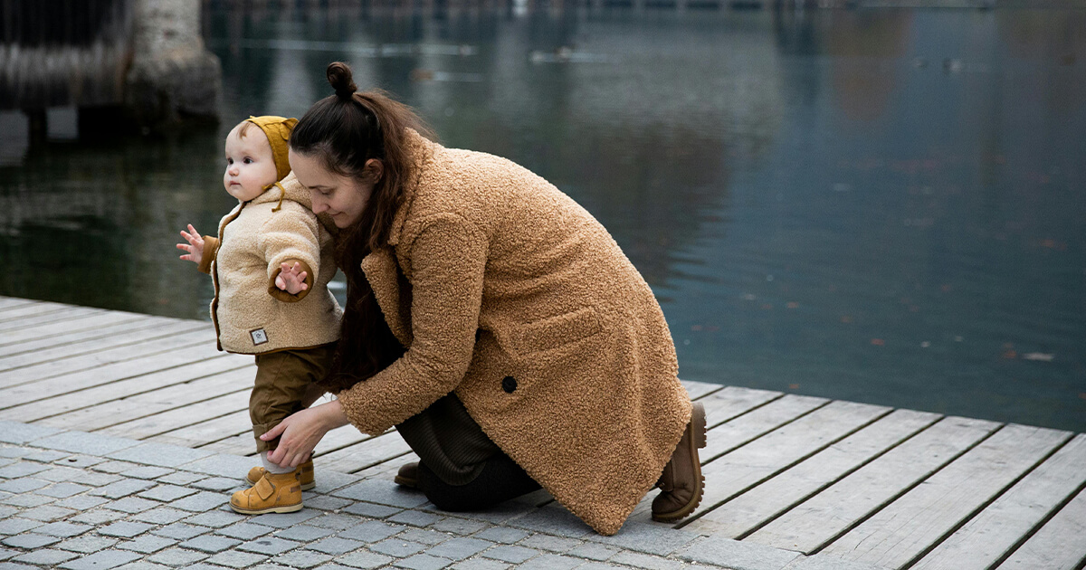 mother with her little daughter with the side of lake