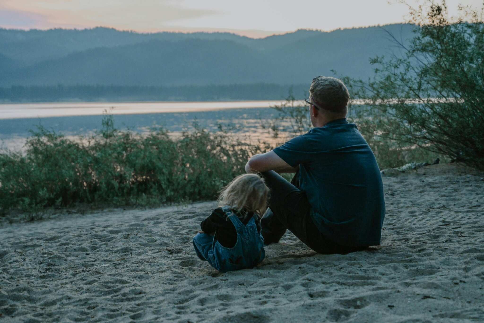 Father Sitting on Sand with a Child