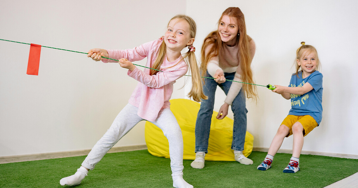 mom playing with kids playing rope pulling game