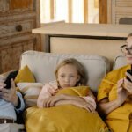 A Girl Sitting on a Couch With Her Grandparents