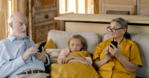 A Girl Sitting on a Couch With Her Grandparents