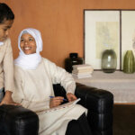 Arabian Muslim mother with son near table with glassware