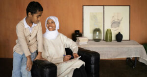 Arabian Muslim mother with son near table with glassware