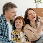 Man and Woman Smiling While Holding White Smartphone