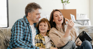 Man and Woman Smiling While Holding White Smartphone