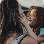 Woman Carrying Girl While Showing Smile