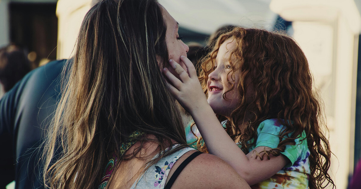 Woman Carrying Girl While Showing Smile