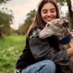 side-view-smiley-woman-hugging-dog