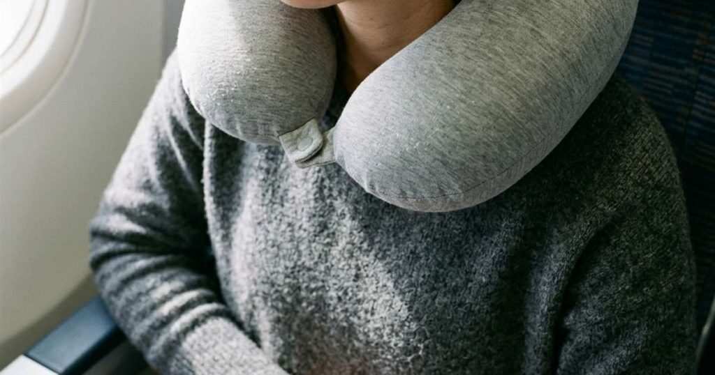Overhead view of a neck pillow worn backward with the bulk under the chin
