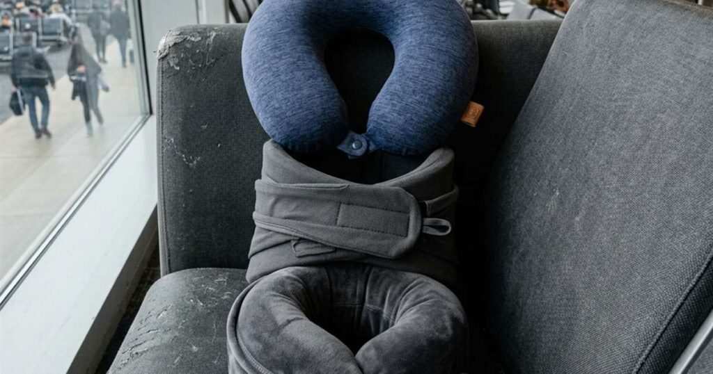 Three different styles of travel pillows arranged on an airport terminal seat