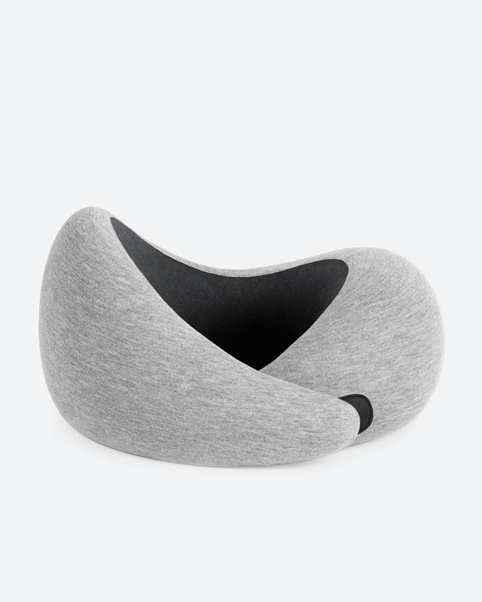 The Ostrichpillow Go Neck Pillow in grey with its asymmetric 360-degree wrap design.